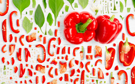 Abstract background made of Red Pepper vegetable pieces, slices and leaves on wooden background.の写真素材