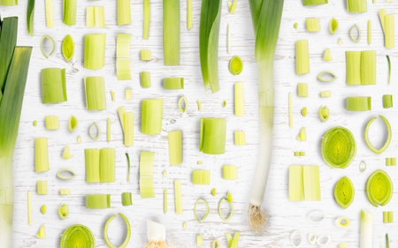 Abstract background made of Leek vegetable pieces, slices and leaves on wooden background.の写真素材