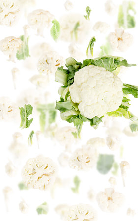 Abstract background made of Cauliflower vegetable pieces, slices and leaves isolated on white.の写真素材