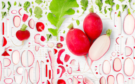 Abstract background made of Radish vegetable pieces, slices and leaves on wooden background.の写真素材