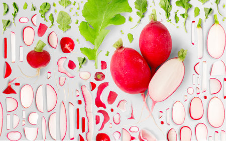 Abstract background made of Radish vegetable pieces, slices and leaves isolated on gray background.の写真素材