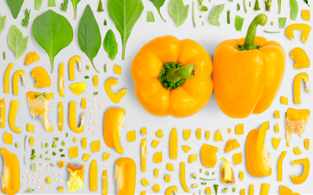Abstract background made of Yellow Bell Pepper vegetable pieces, slices and leaves isolated on gray background.の写真素材