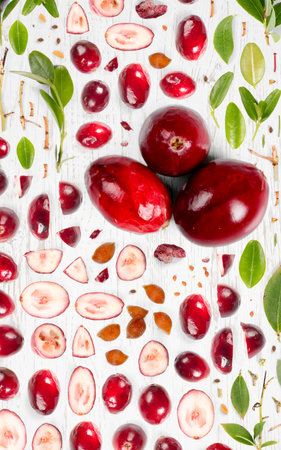 Cranberry fruit piece, slice and leaf collection. Flat lay, seamless abstract, wooden background.の写真素材
