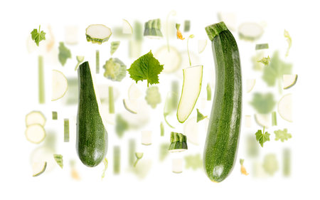 Abstract background made of Zucchini vegetable pieces, slices and leaves isolated on white.の写真素材