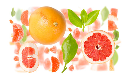 Abstract background made of Grapefruit fruit pieces, slices and leaves isolated on white.の写真素材