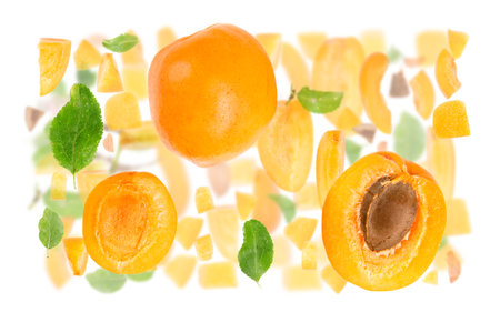 Abstract background made of Apricot fruit pieces, slices and leaves isolated on white.の写真素材