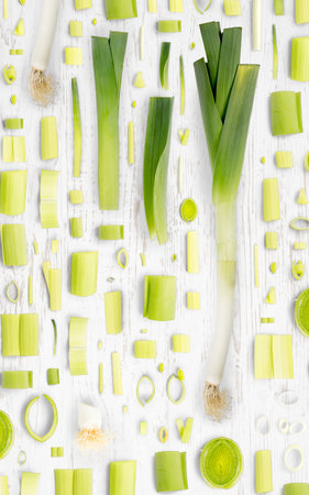 Abstract background made of Leek vegetable pieces, slices and leaves on wooden background.の写真素材