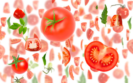Abstract background made of Red Tomato vegetable pieces, slices and leaves isolated on white.の写真素材