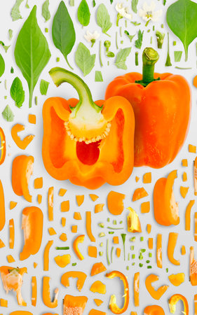 Abstract background made of Orange Bell Pepper vegetable pieces, slices and leaves isolated on gray background.の写真素材