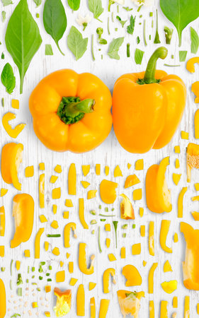 Abstract background made of Yellow Bell Pepper vegetable pieces, slices and leaves on wooden background.の写真素材