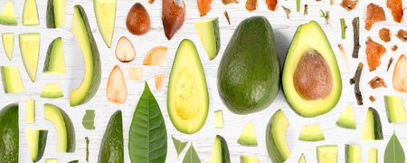 Avocado fruit piece, slice and leaf collection. Flat lay, seamless abstract on wooden background.の写真素材