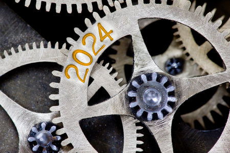 Photo of tooth wheel mechanism with number 2024 and arrows imprinted on metal surface. New Year concept.の写真素材