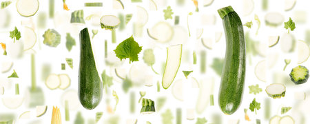 Abstract background made of Zucchini vegetable pieces, slices and leaves isolated on white.の写真素材