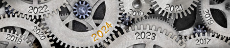 Photo of tooth wheel mechanism with numbers 2024, 2023, 2022 imprinted on metal surface. New Year concept.の写真素材