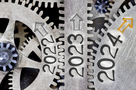Photo of tooth wheel mechanism with numbers 2024, 2023, 2022 and arrows imprinted on metal surface. New Year concept.の写真素材