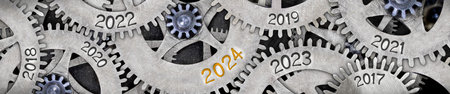 Photo of tooth wheel mechanism with numbers 2024, 2023, 2022 imprinted on metal surface. New Year concept.の写真素材