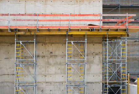 Construction Site with Concrete Wall and Scaffoldingの写真素材