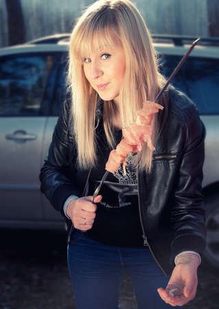 A young woman in the forest cooking shashlikの写真素材