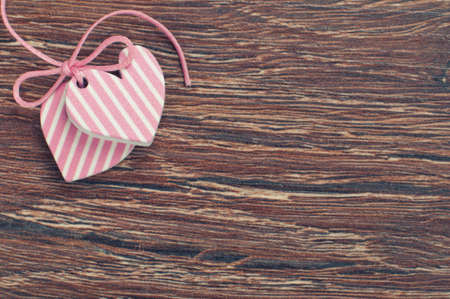 pink hearts on wooden board with pink ribbonの写真素材