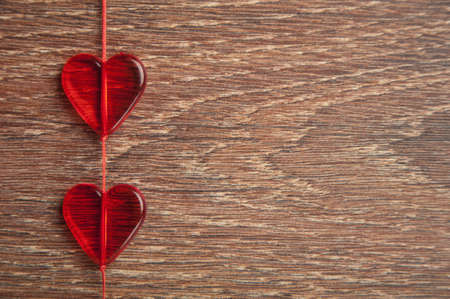 two red hearts on wooden boardの写真素材