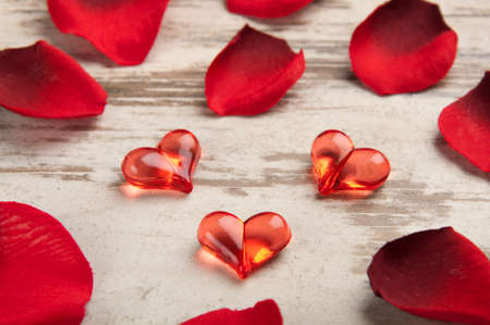 red hearts on the wooden board with petalsの写真素材