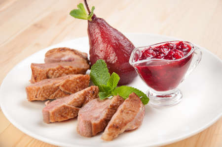 Roast duck breast with raspberry sauce and pearsの写真素材