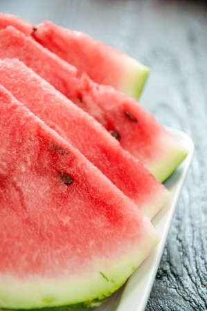 Ripe watermelons on table on wooden backgroundの写真素材