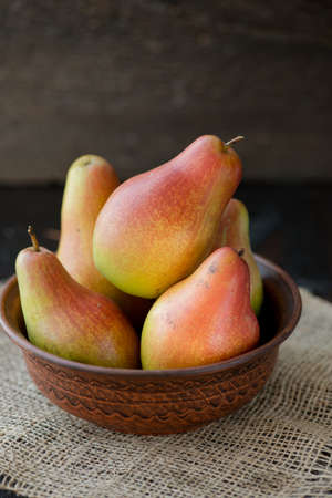 fresh pears in the plate, on the wooden backgroundの写真素材