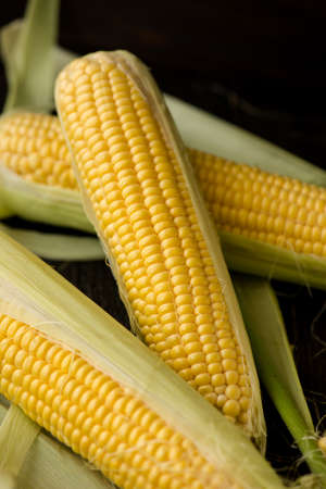 Organic sweet corn on wooden table. Selective focus.