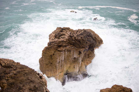 Wave crashing on a coast in Nazare, Portugal