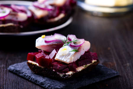 Sandwiches with herring and beetroot on a slate black plateの写真素材