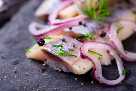 Sliced herring salad on a black slate plateの写真素材