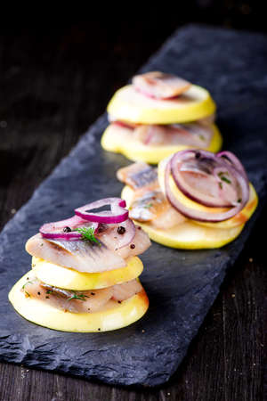 Appetizer canape with herring and applesの写真素材
