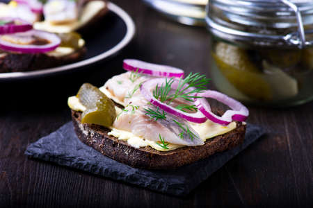 Sandwich with butter, herring on a black slate plateの写真素材