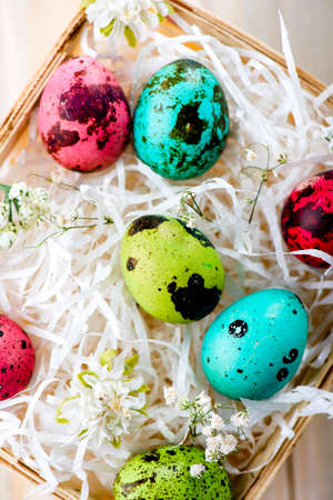 Colorful Easter eggs in the basket on wooden backgroundの写真素材