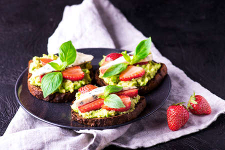 Fresh toast with strawberry on dark plate