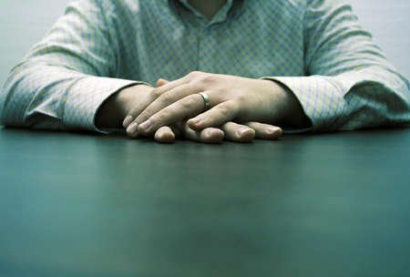 male hands on a brown table waiting for a partner for discussionの写真素材