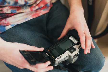 A man fills the camera film. put film in the camera.