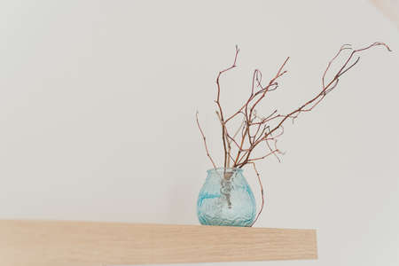 Light shelf on the wall with decor. A branch in a vase. Scandinavian minimalism in the interior.の写真素材