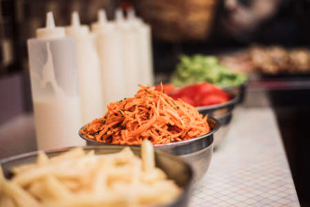 Drinks with tomatoes, cucumbers, Korean carrots and french fries, sauce dishes on the background of...