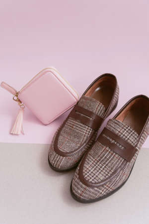 Beige walkers and a pink wallet on a pastel double background. concept of female shopping and...