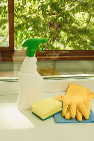 detergent, sponge, gloves on the background of the window. Tools for cleaning windows.の写真素材