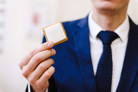 businessman holds cookies in his hands with an empty place for text. A man in a suit holds a blank tablet in his hands.の写真素材