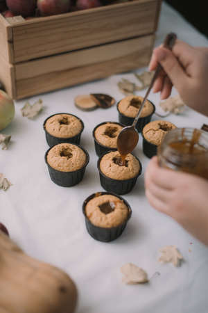 The baker creates cupcakes in molds. Filling biscuits with homemade liquid caramel.の写真素材