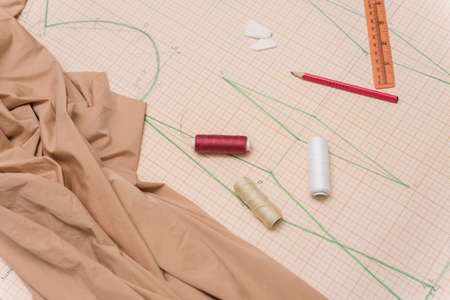 Drawing drawing for sewing clothes. Scissors, fabric, drawings and cutting on the table seamstress....