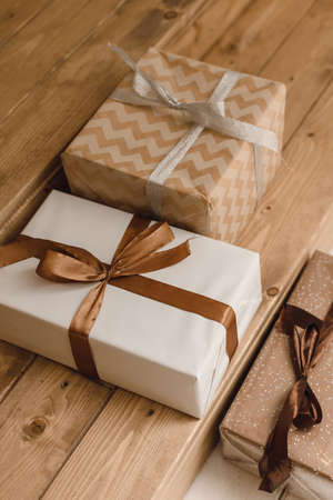 Christmas gifts in Kraft paper on wooden doorstep. New Year's gifts for children on Christmas...