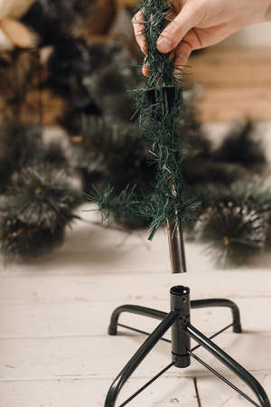 Man collects artificial Christmas tree at home. The stage of Assembly of the framing tree. Instruction and help.の写真素材