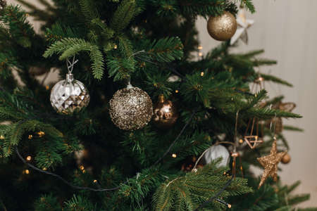 Silver, brown and gold ornaments and balls on the Christmas artificial tree in the house.の写真素材