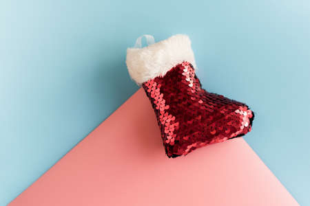 Holidays symbol stocking. Red christmas sock. Christmas tree toy on a pastel background. Santa sock...