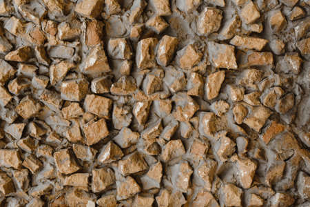 Wall of an old house made of grunge stones covered with dust and dirt. Old brown masonry on the wall...